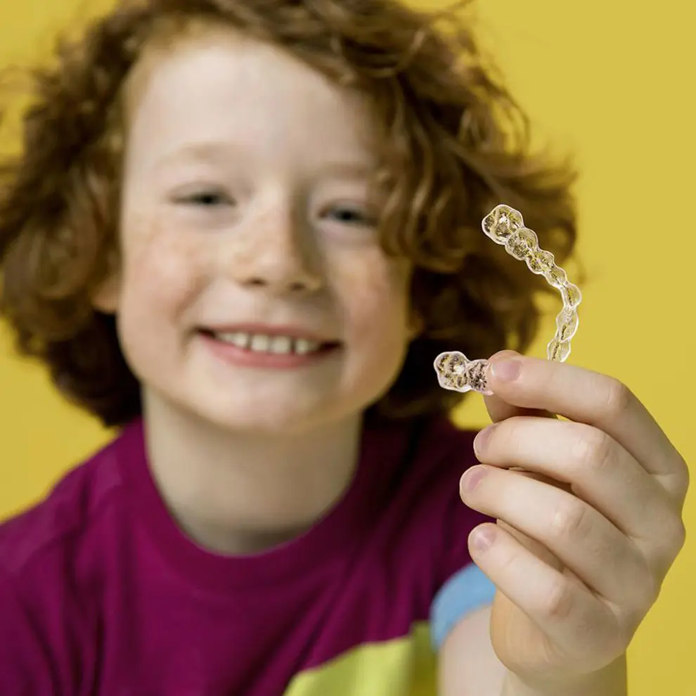 photo-hero-red-hair-boy-holding-invisalign-first-aligners